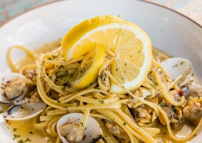 alt=" A plate of pasta with seafood and lemon on top of it"