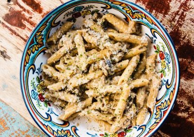 alt=" A plate of penne with a cheese sauce on top of it"